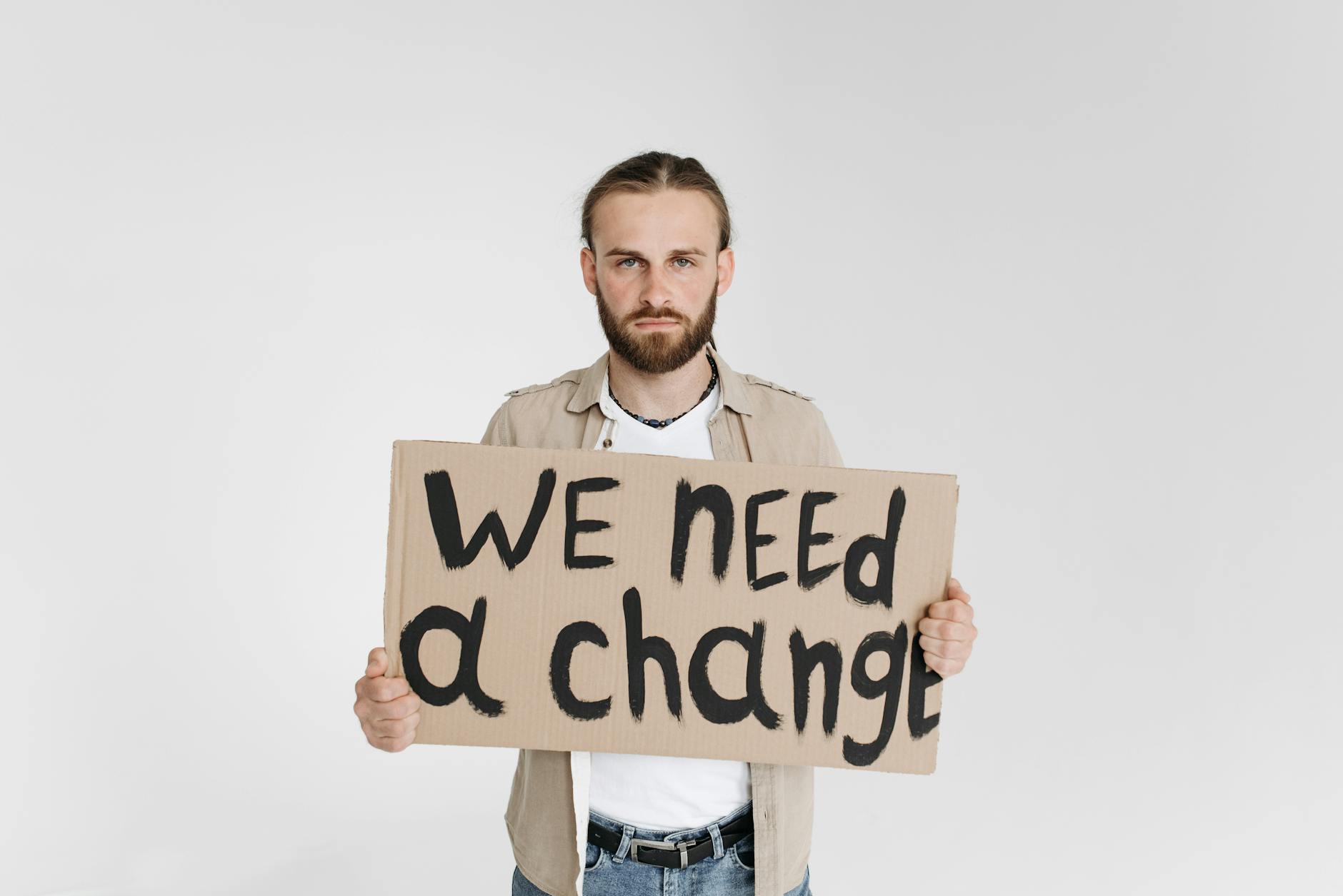 A close-up of a student holding a sign with a clever debate topic written on it. — debate topics for students
