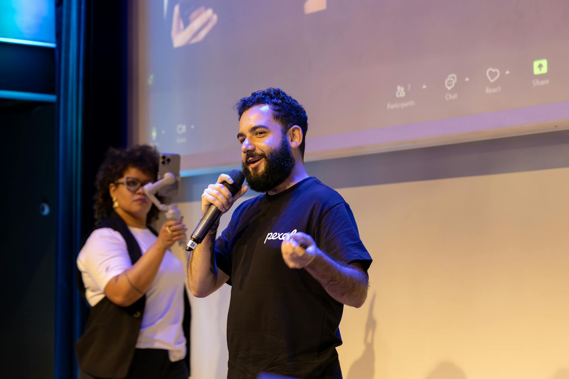A speaker using a live poll on a screen to engage the audience during a debate. — engaging debate audience