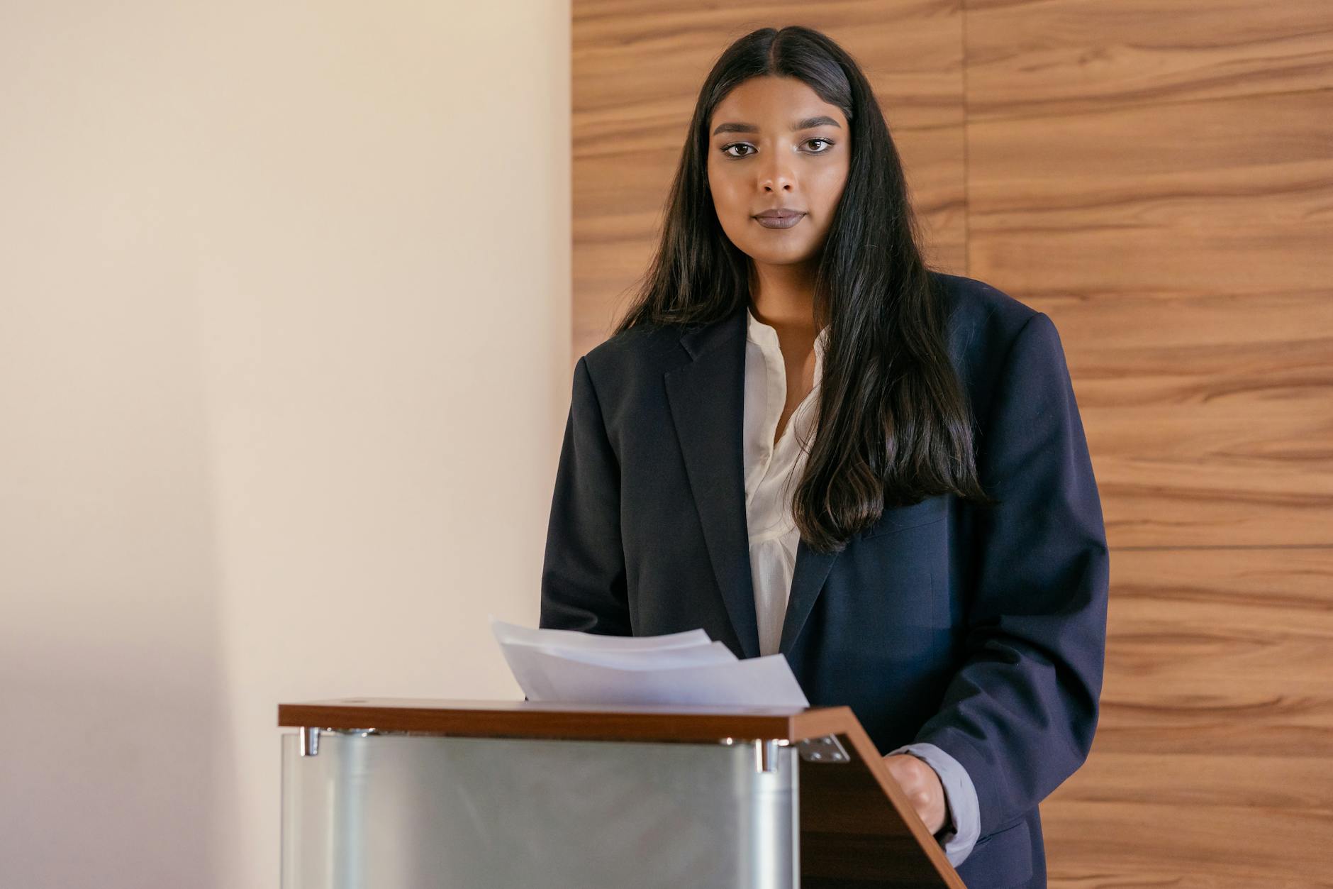 A woman standing confidently at a podium, delivering her debate speech. — women in debate