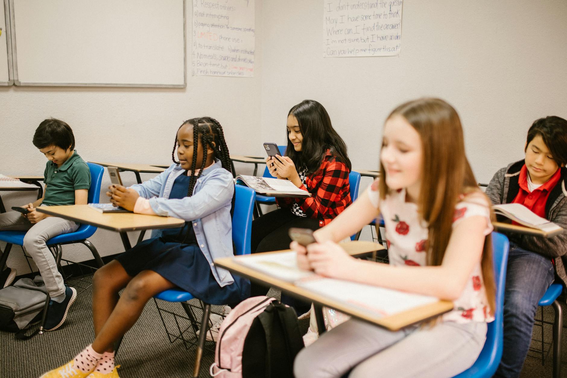 A classroom setting with students engaged in learning while using mobile phones responsibly, highlighting positive use in …