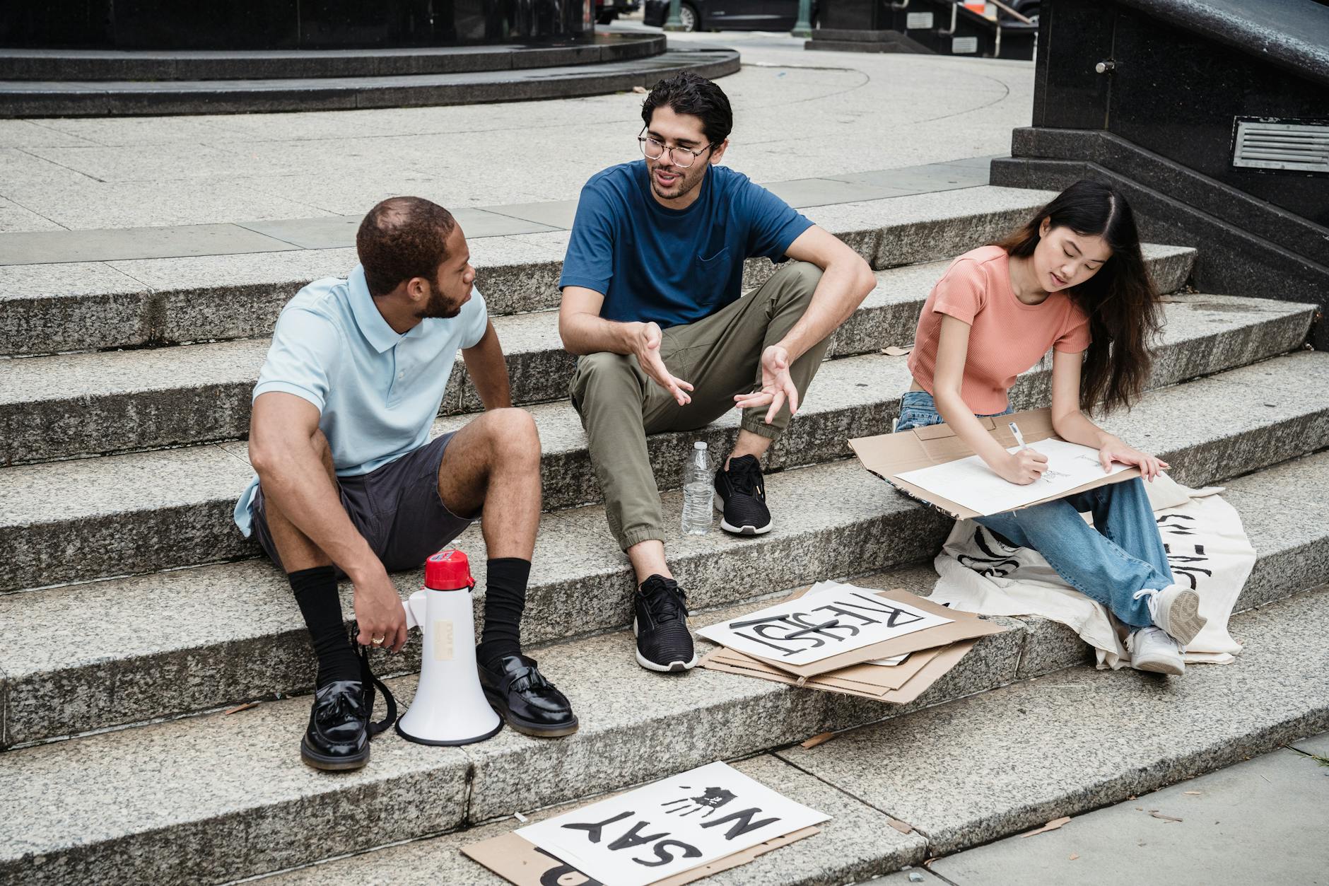A diverse group of young people discussing climate change solutions in an outdoor setting. — climate change debates