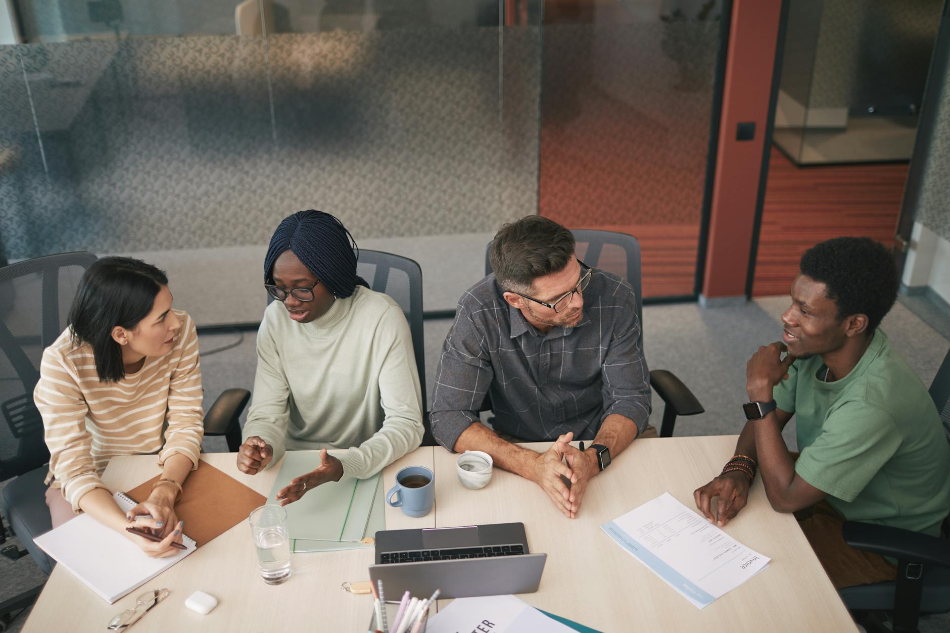 A group of people engaged in a lively discussion around a table. — debate vs discussion