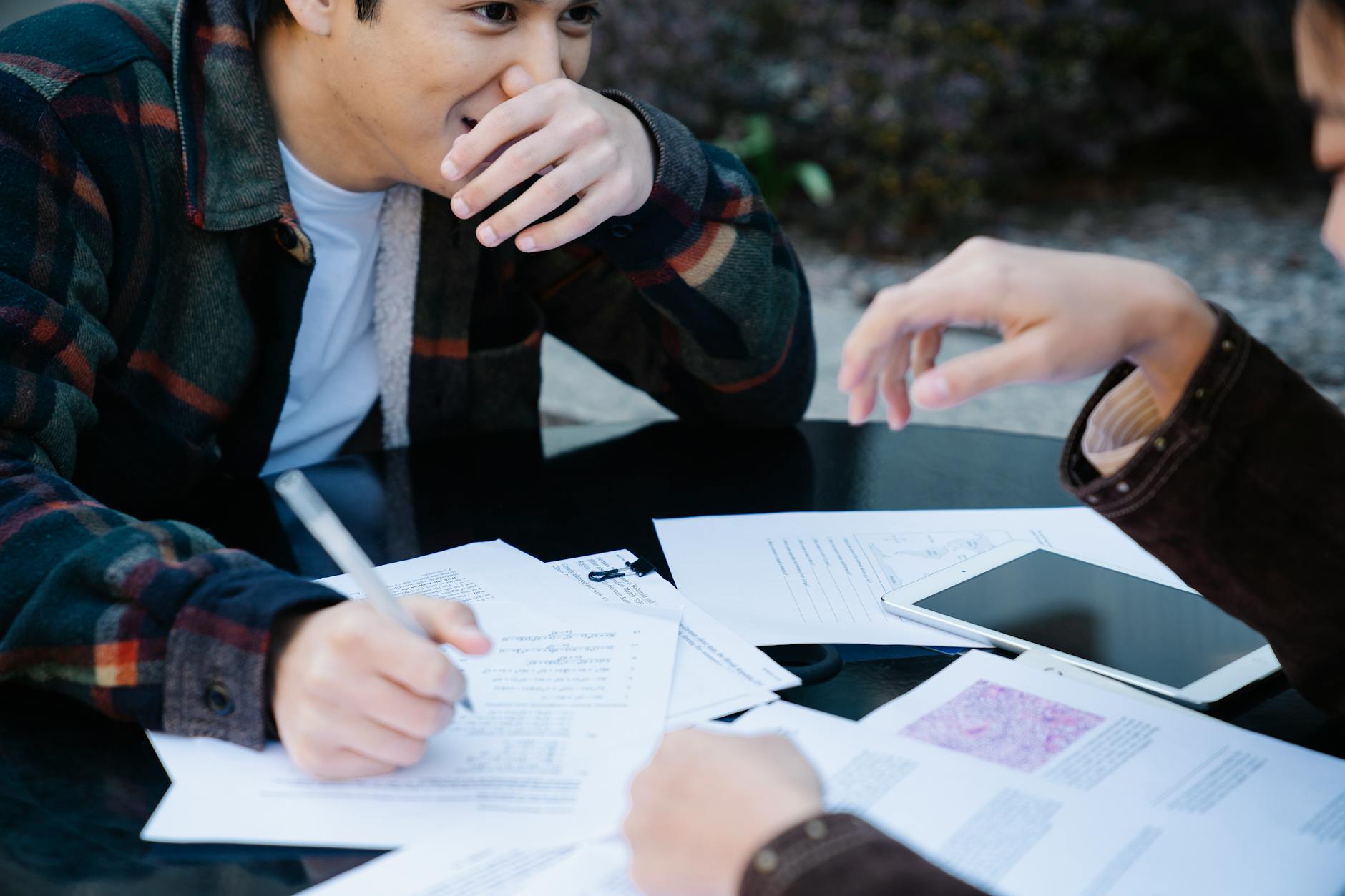 A group of students brainstorming debate topics around a table. — choose debate topic