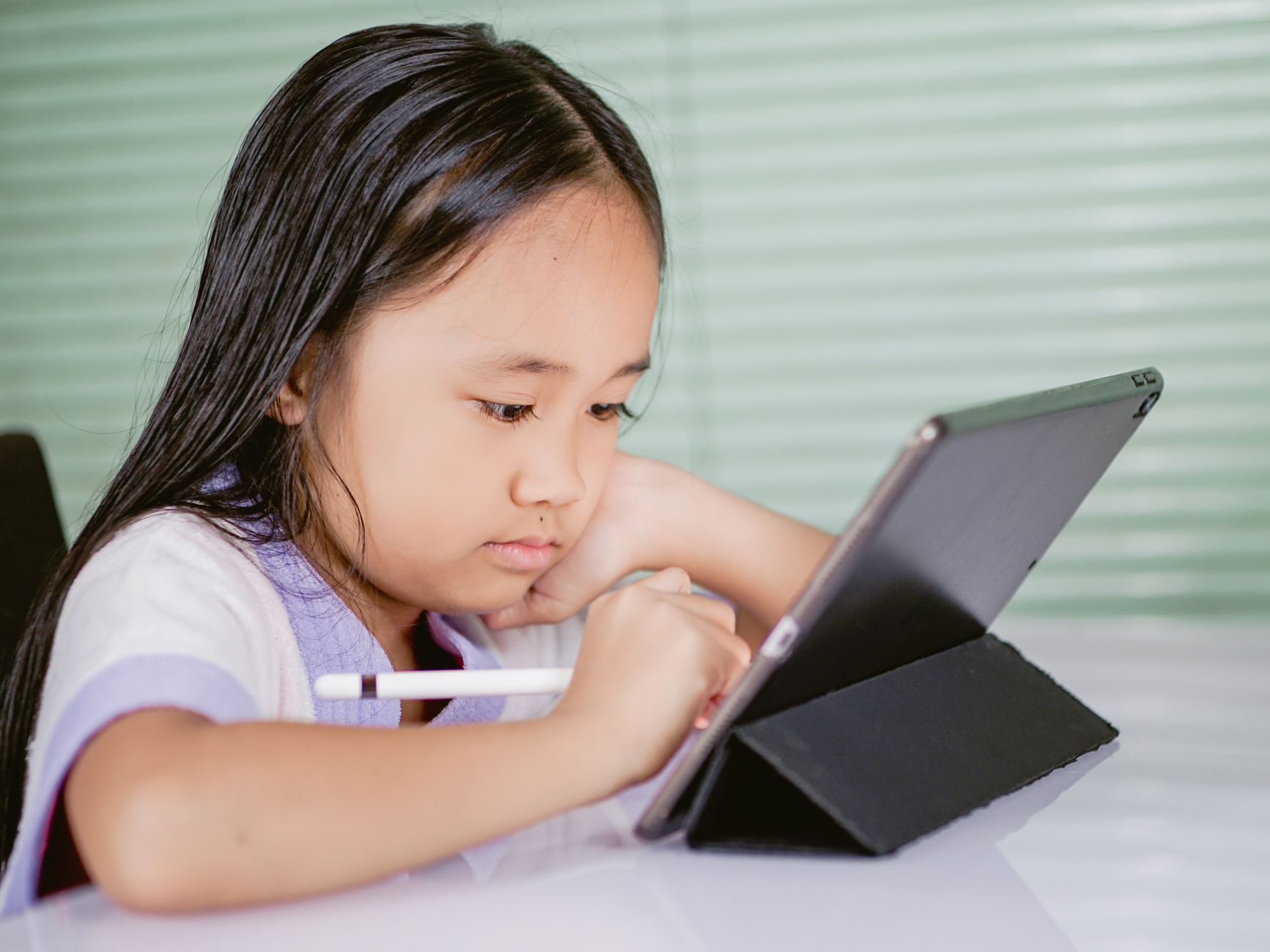 A child using a smartphone in a study area, focused on learning apps. — kids smartphone debate
