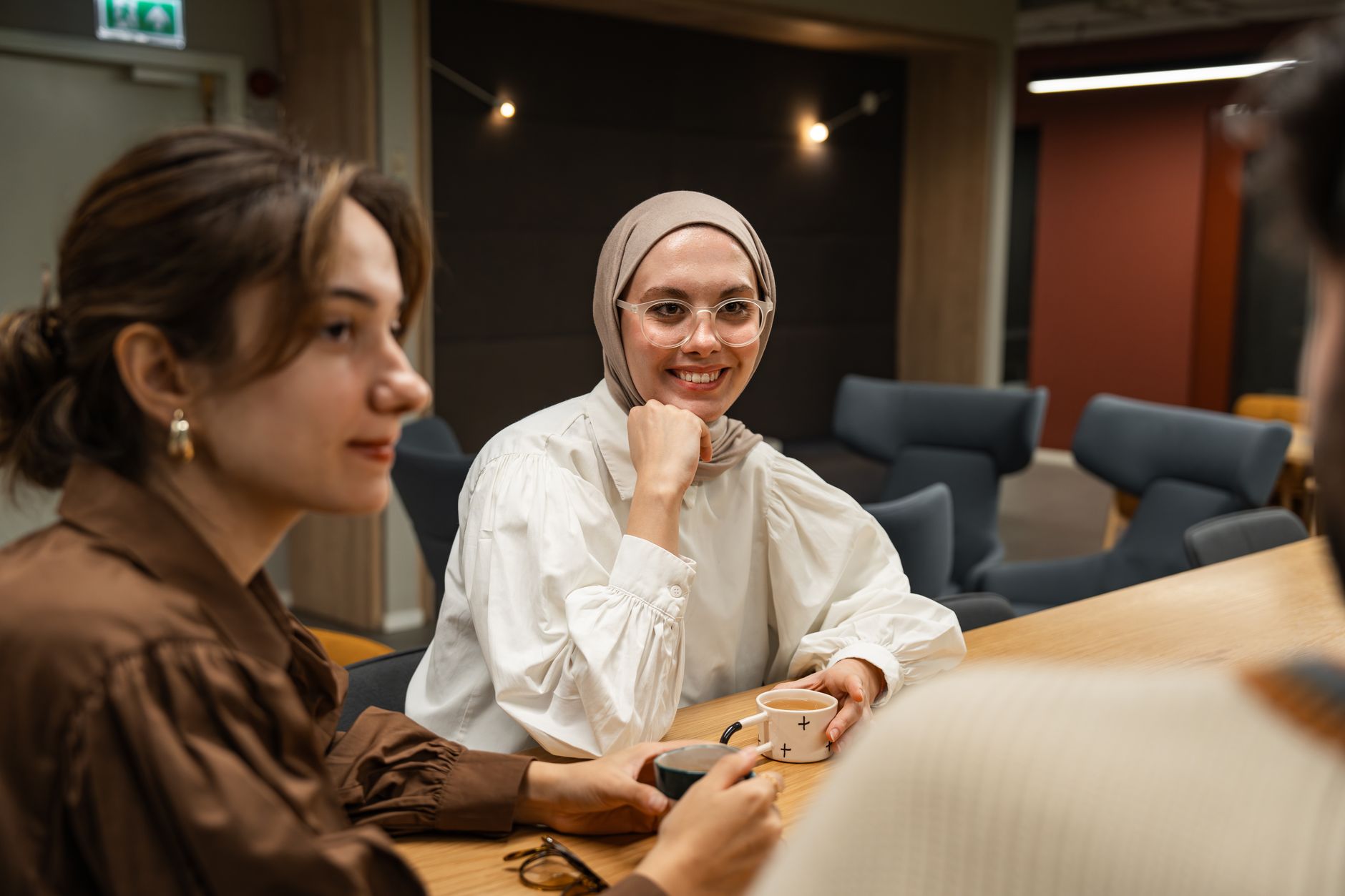 A group of friends engaging in a friendly debate over coffee, showcasing healthy discussion. — debate skills