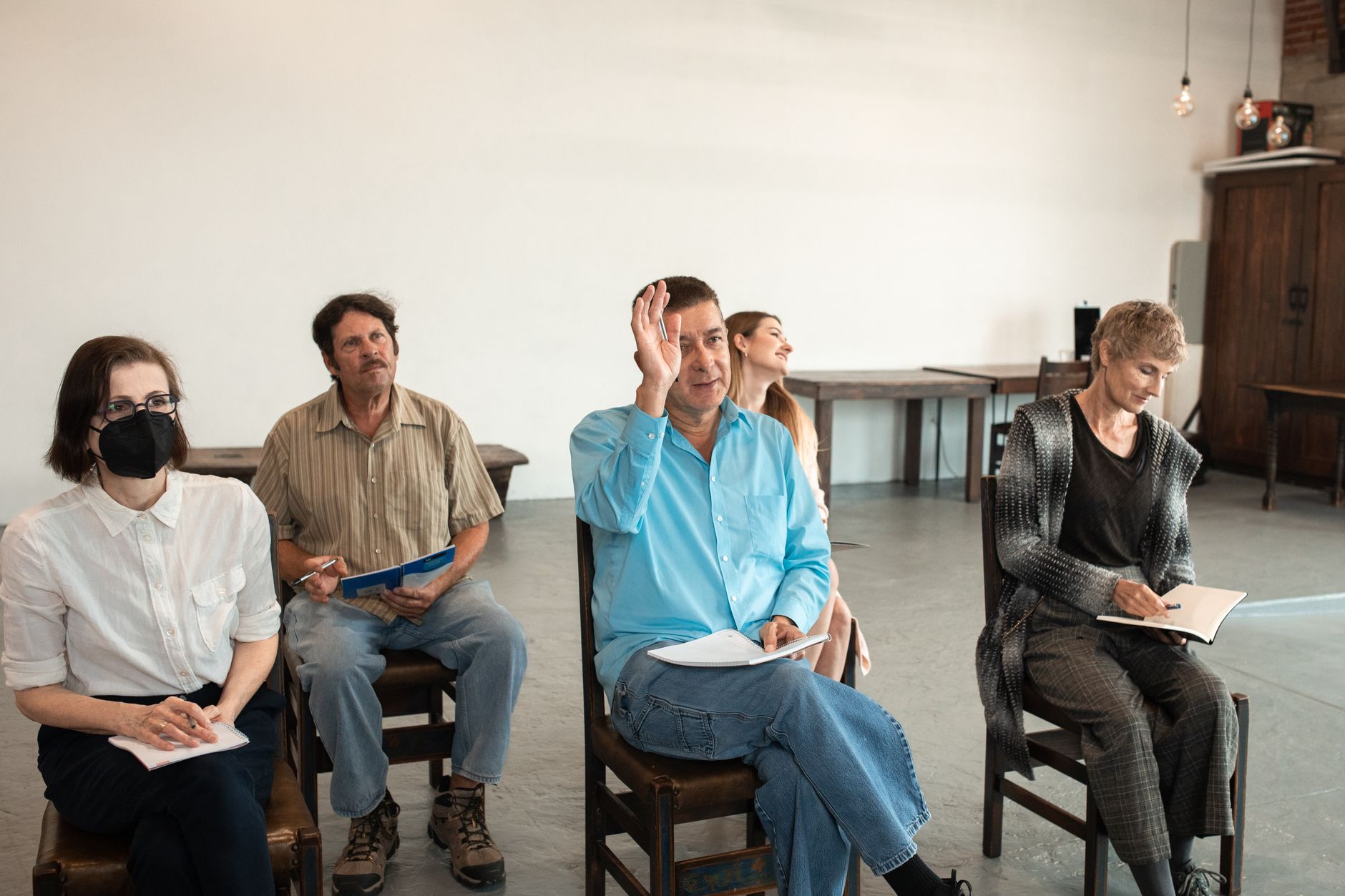 A group of people engaged in a debate, with one person actively listening and taking notes. — listening in debates
