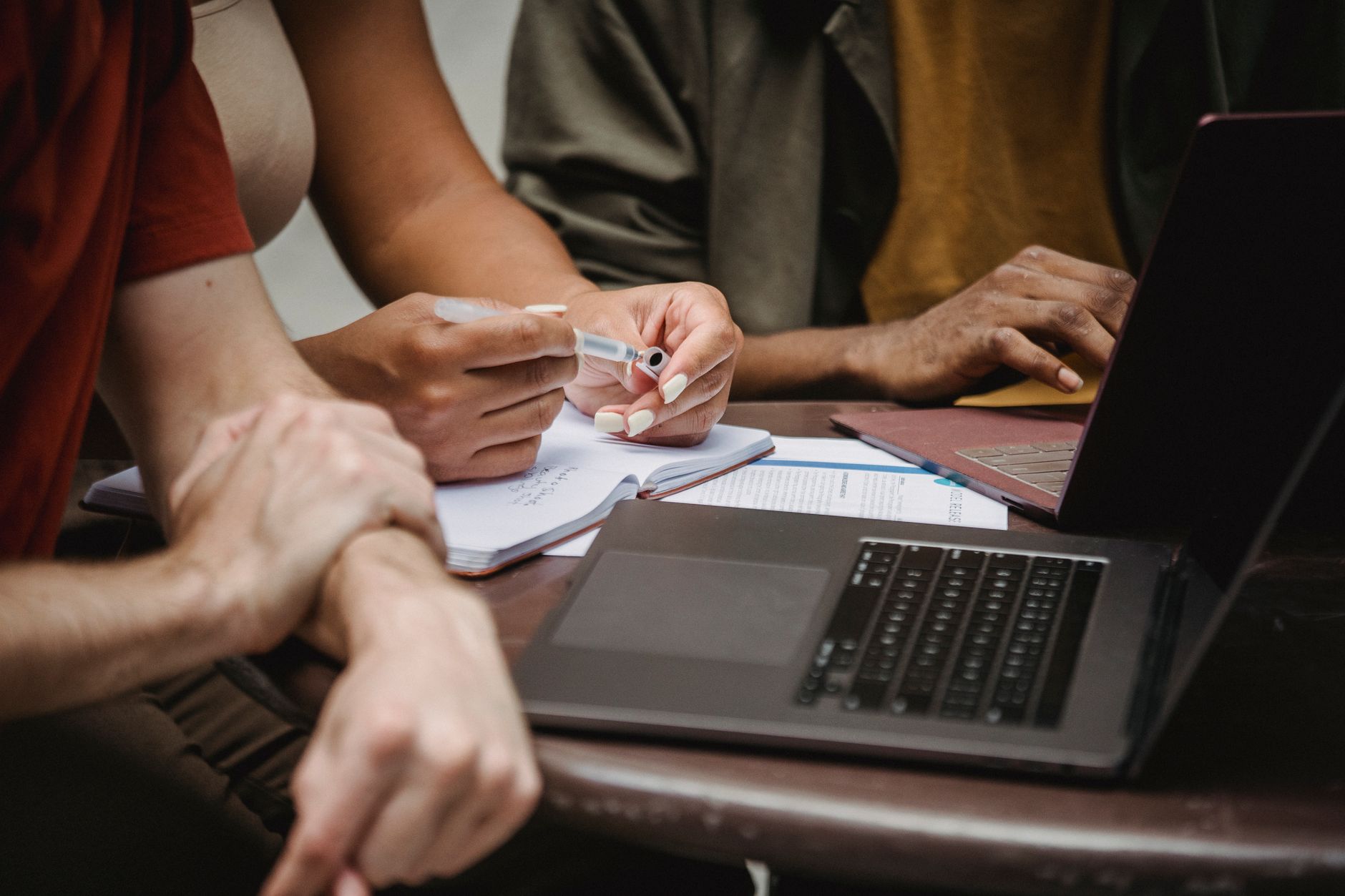 A person analyzing their opponent's arguments with notes and a laptop, representing research in debate strategies.