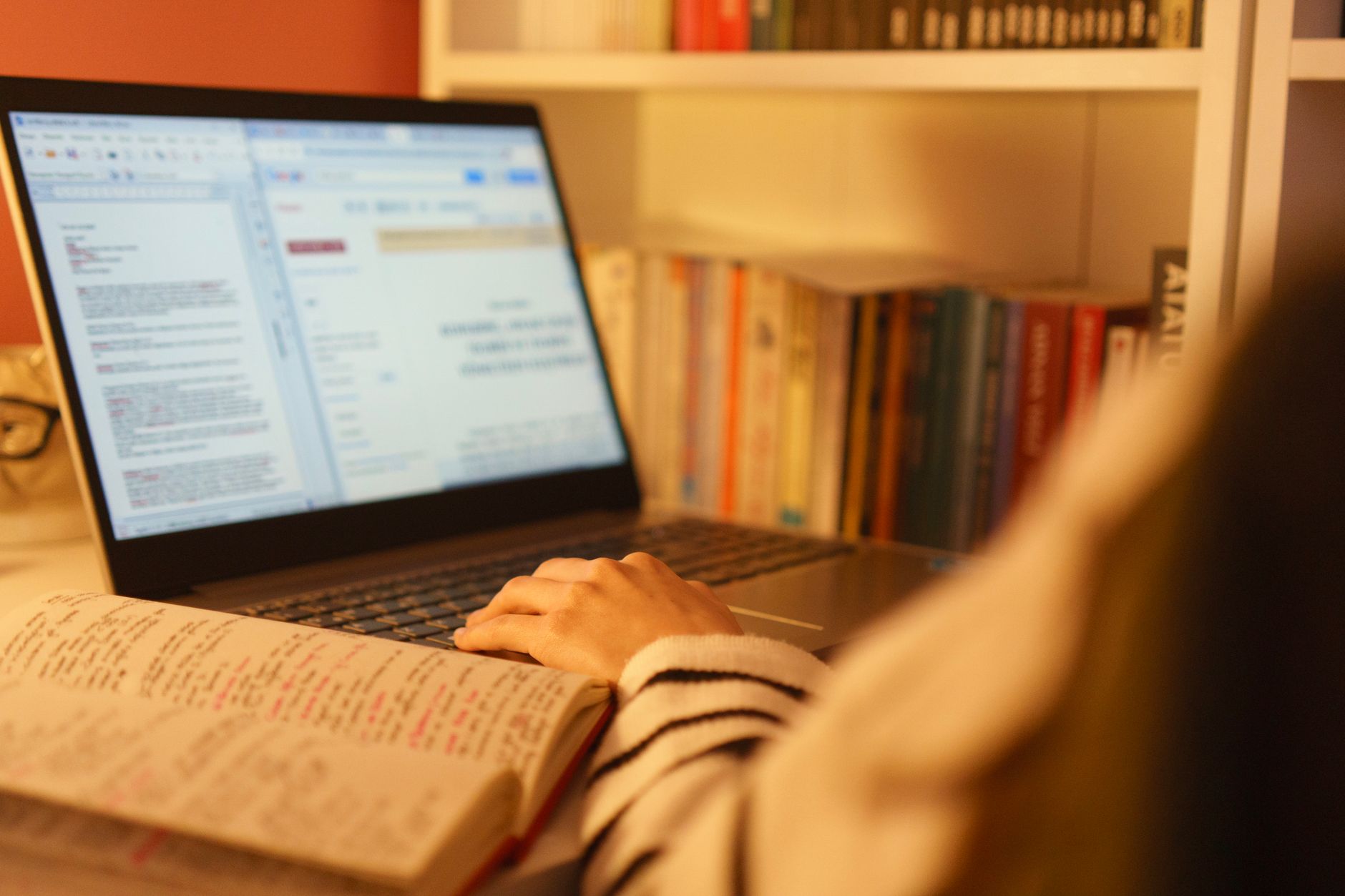 A person researching debate topics on a laptop with notes and books around, emphasizing thorough preparation. — prepare …