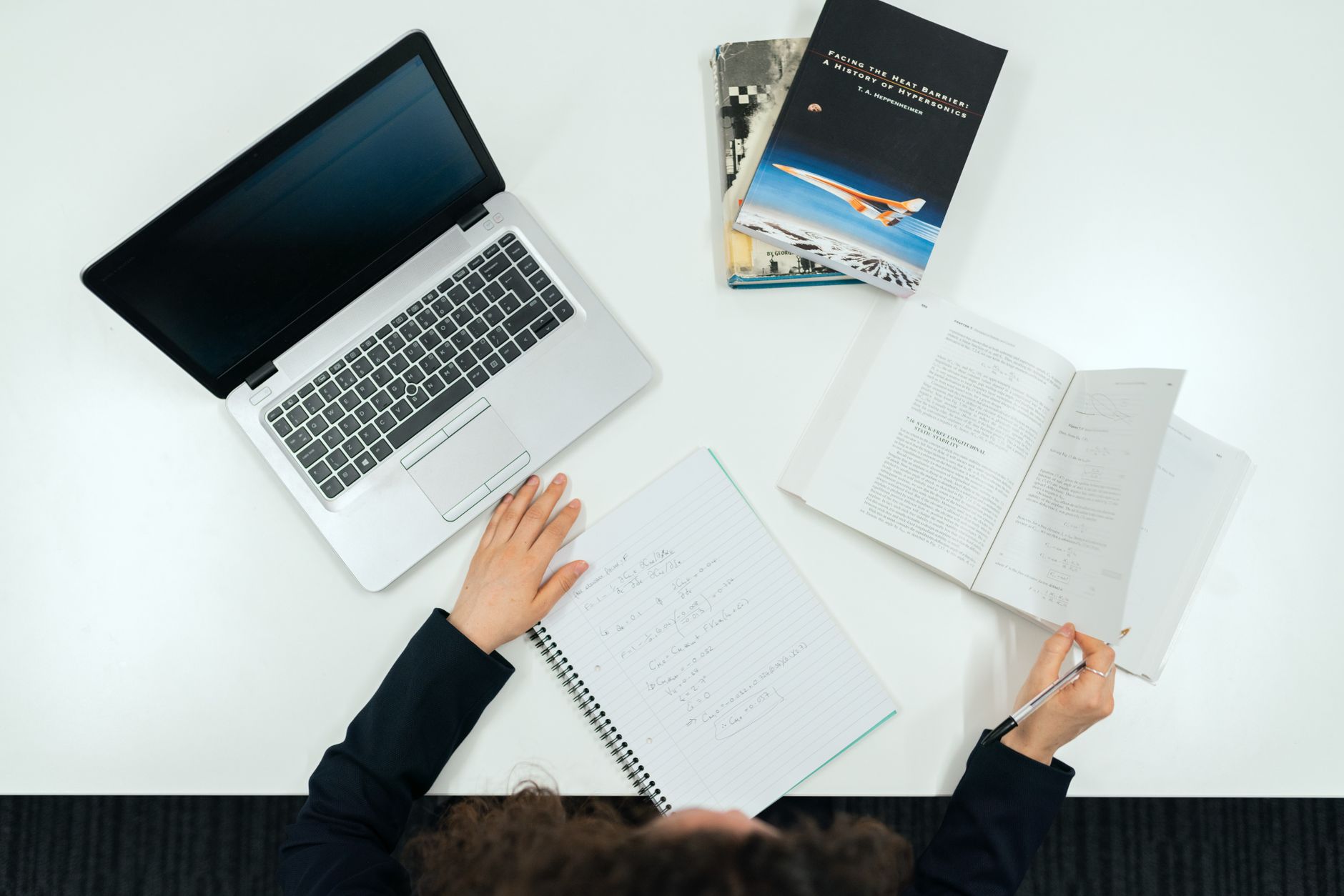 A professional debater researching their topic at a desk filled with books and notes. — debate preparation tips