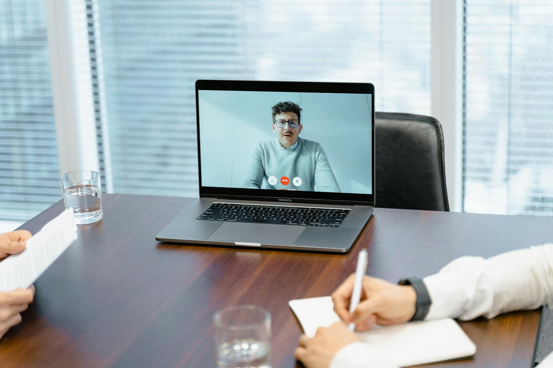 A split image showing a collaborative in-person meeting versus a remote video conference. — future of work