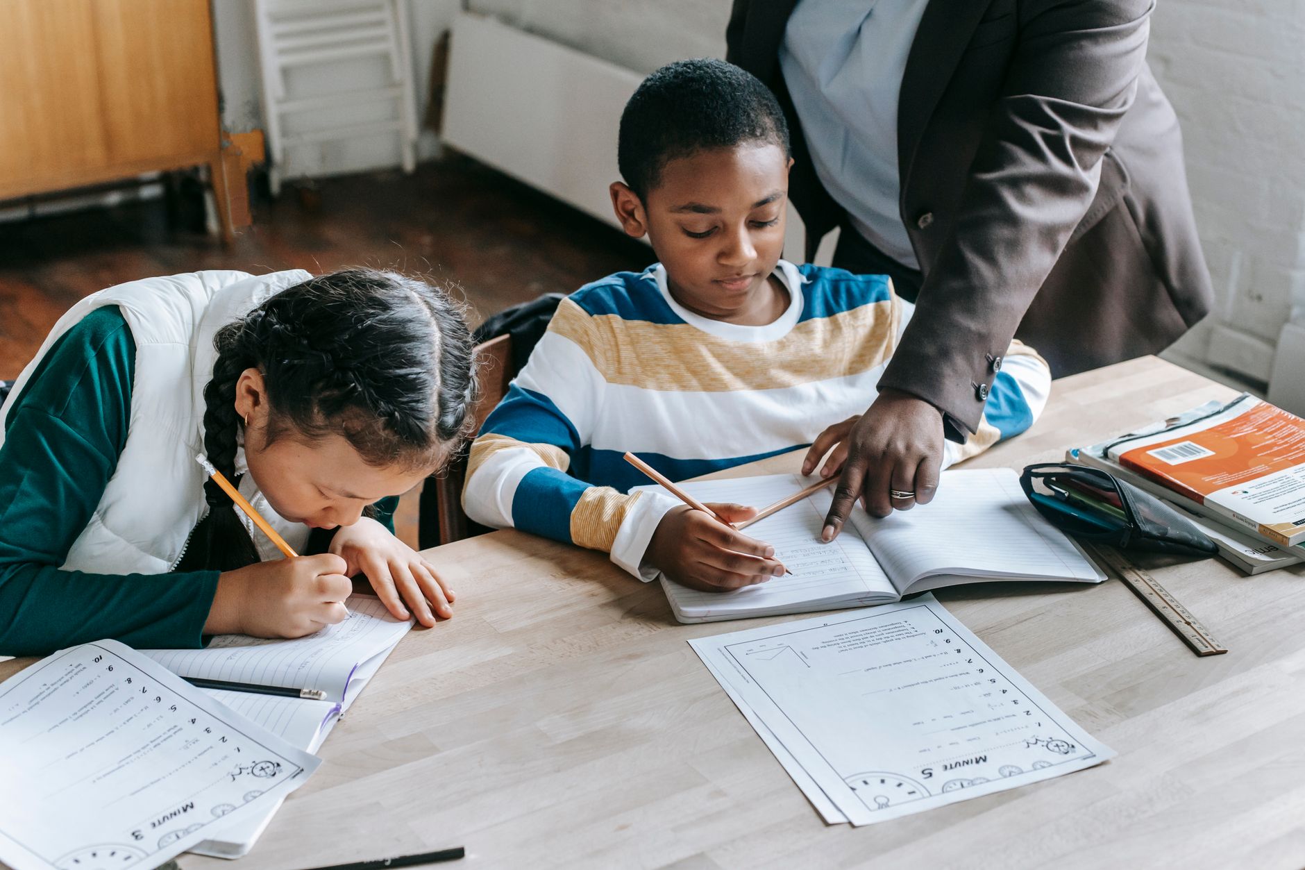 A classroom scene showing students engaged in homework assignments, illustrating the educational aspect of the homework necessity debate.