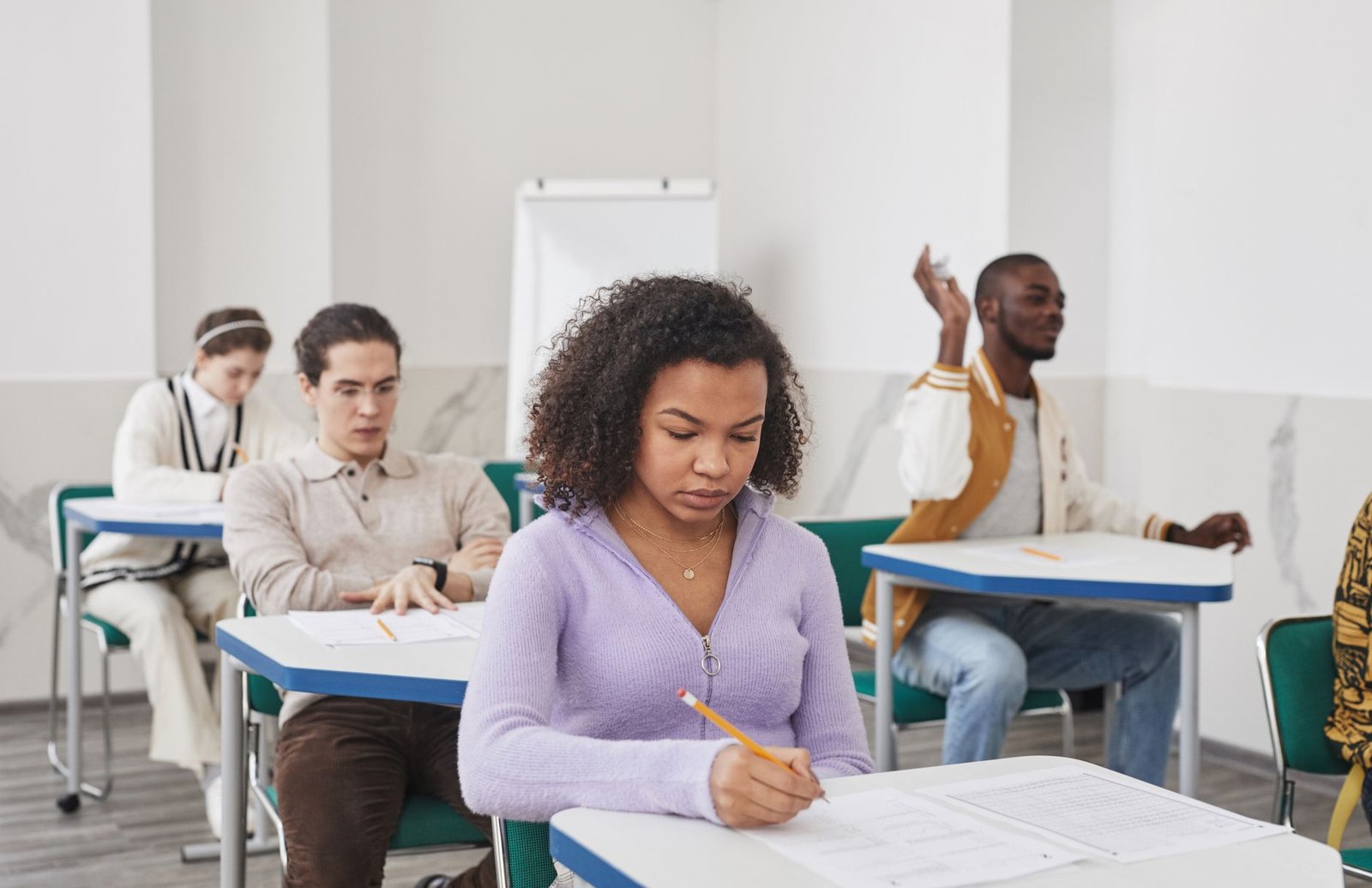 A classroom setting with students taking an open book exam, showing diverse resources available to them. — exam system d…