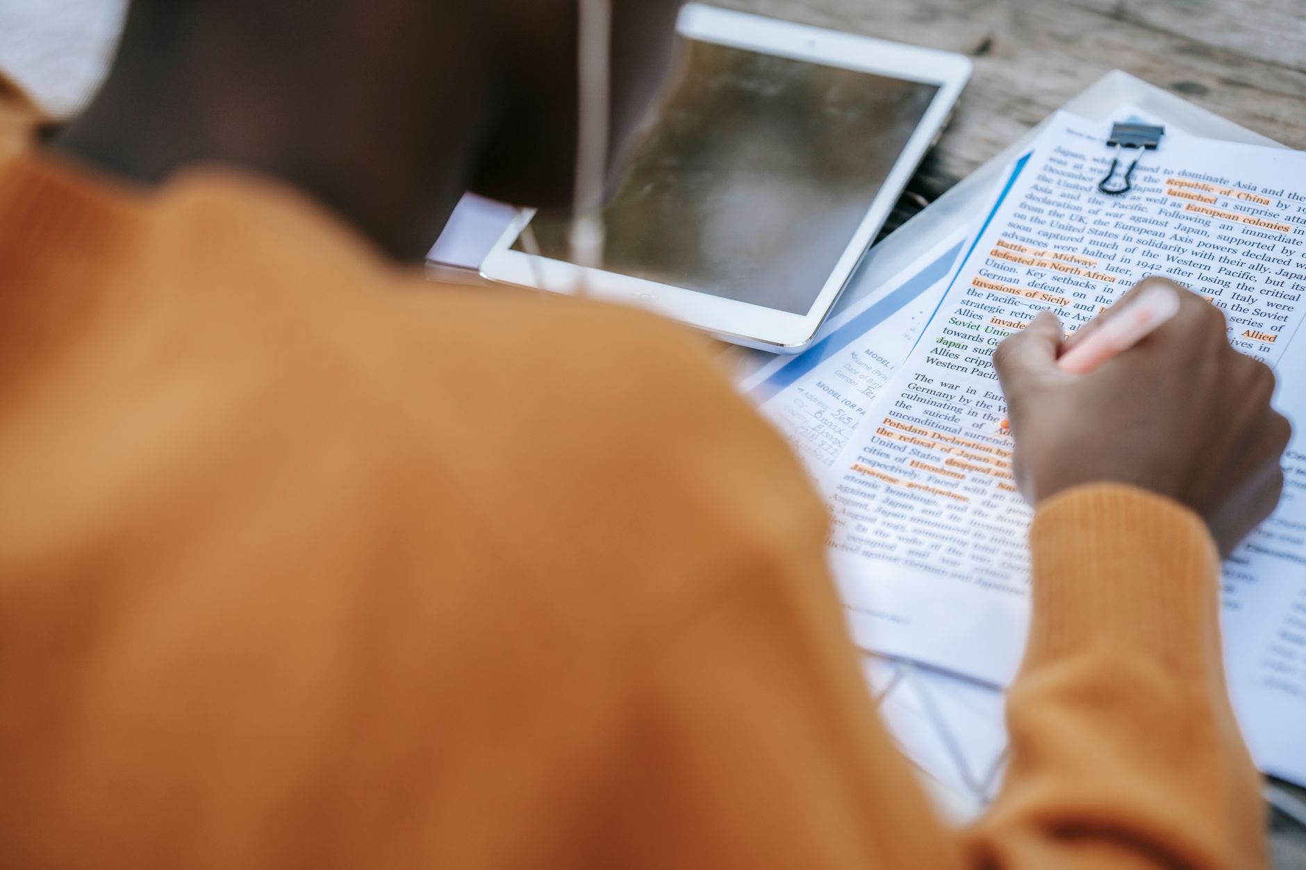 A close-up of a participant reviewing notes and research materials before a debate. — debate preparation