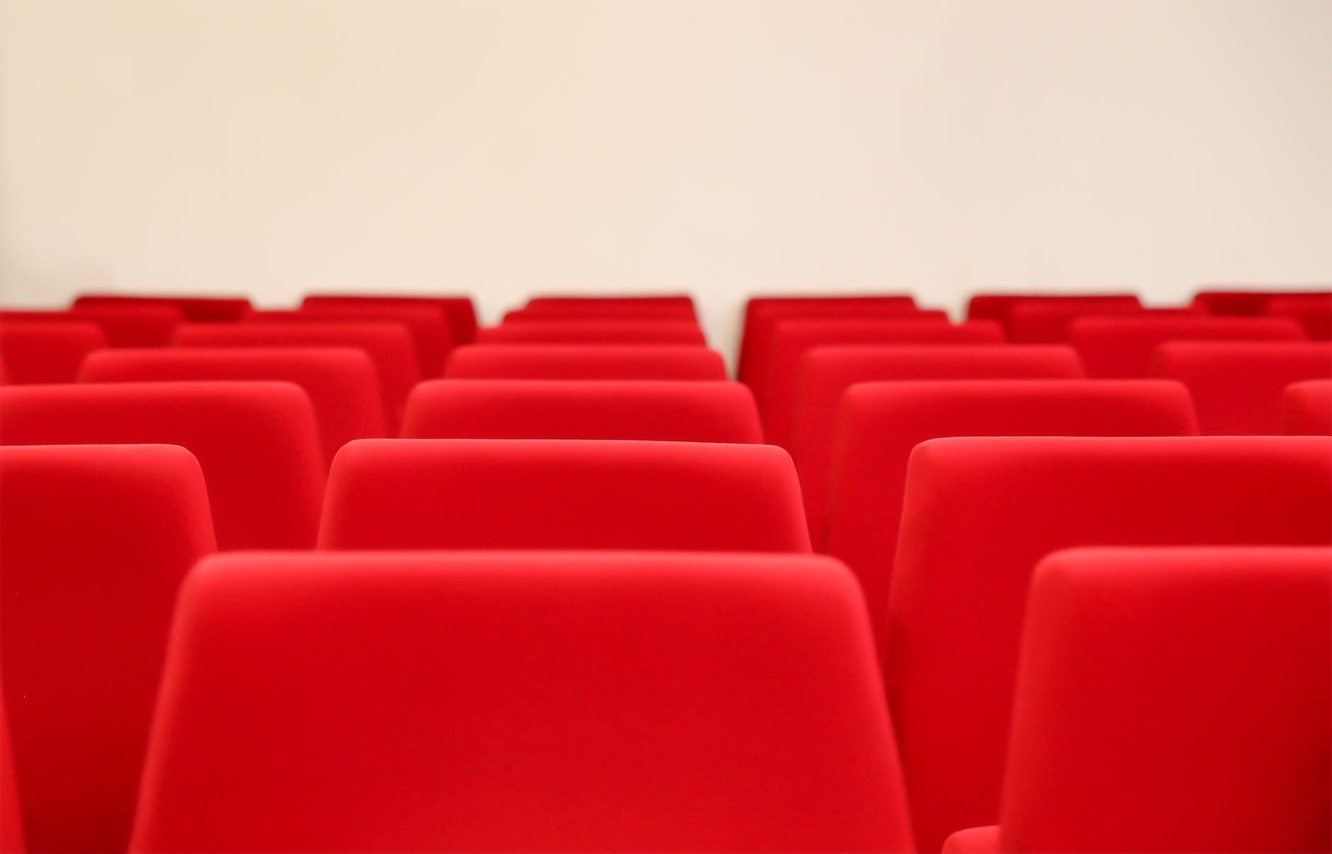 A conceptual image showing a debate stage with empty seats, symbolizing the impact of cancel culture on public discourse. …