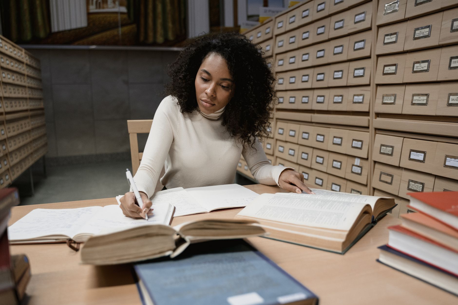 A photo of a student conducting research in a library or online, focusing on research in debating