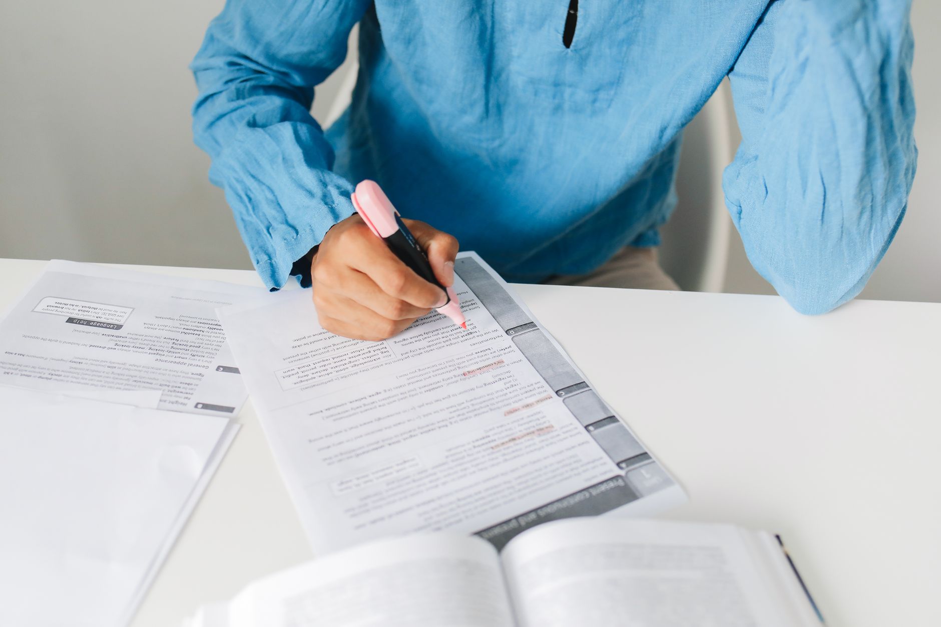 Image of a person researching debate topics with books and a laptop, highlighting the importance of preparation. — debat…