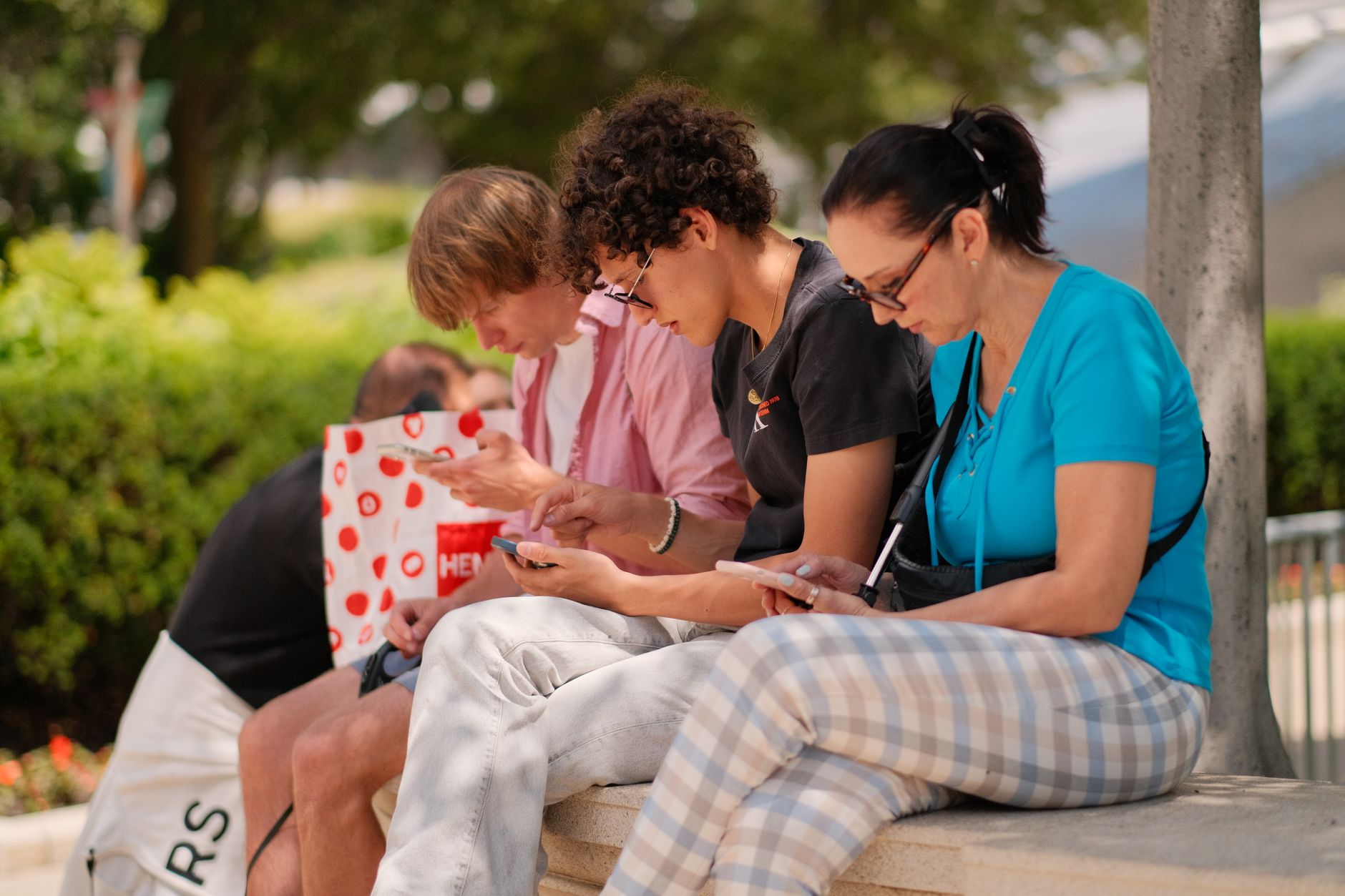 Photo of a diverse group of people using mobile payment apps in a public space. — cashless society debate