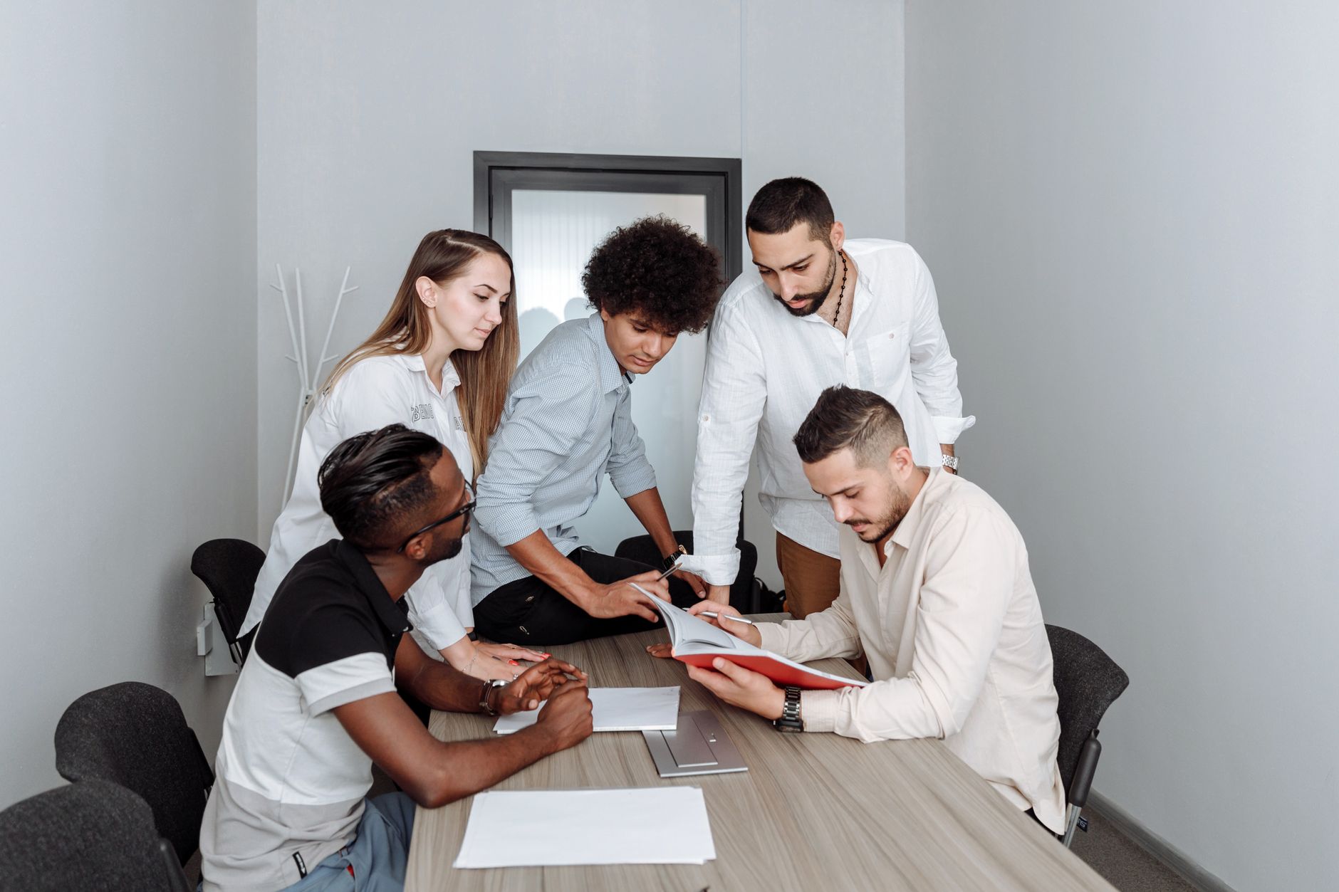 Photo of a diverse group of young adults discussing financial goals — Gen Z vs Millennials