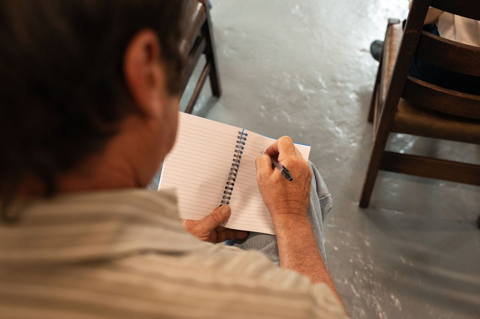 A close-up of a participant taking notes during a debate session. — critical thinking debate