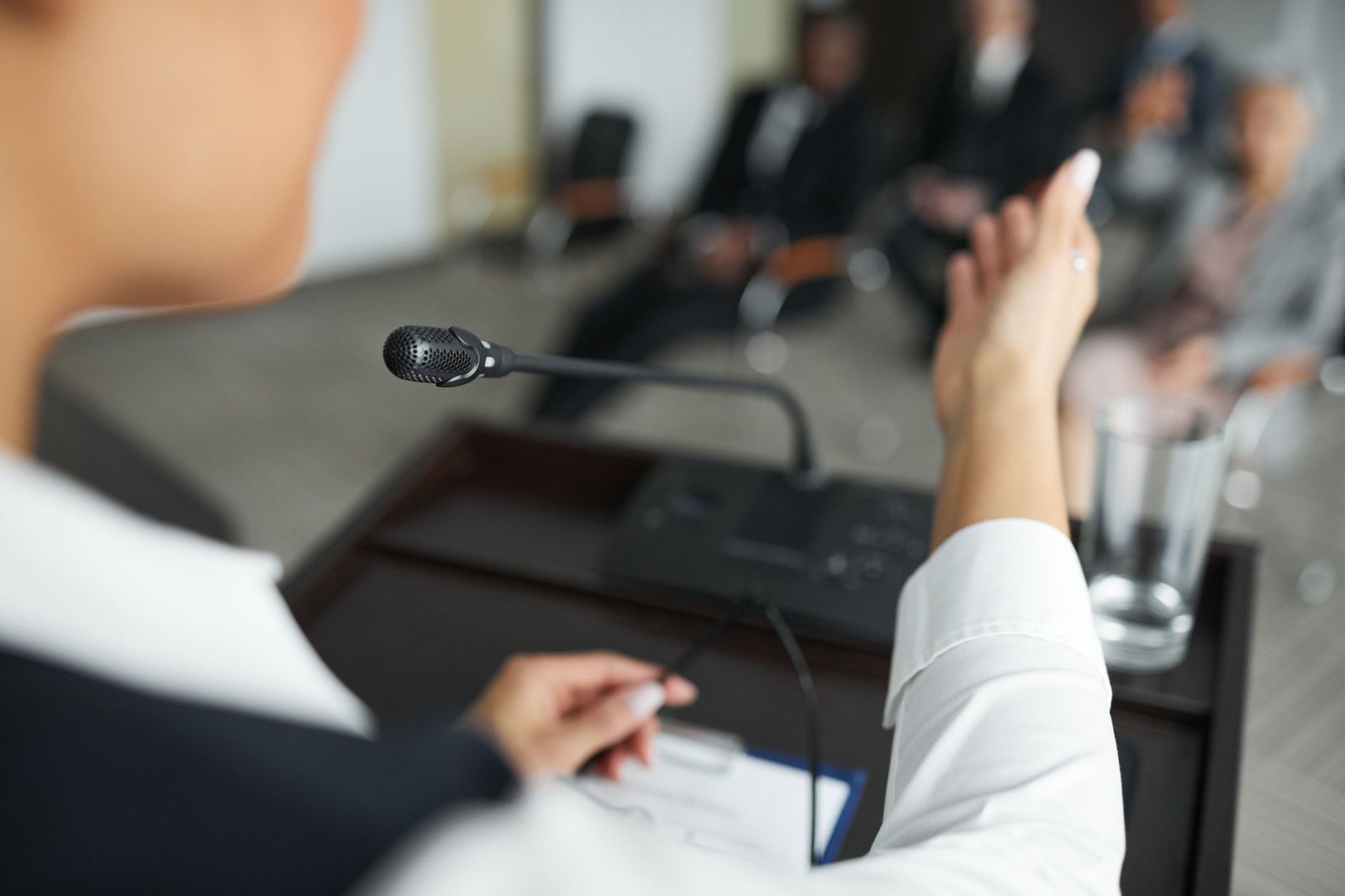 A close-up of a student confidently presenting their argument in front of an audience. — debate club benefits
