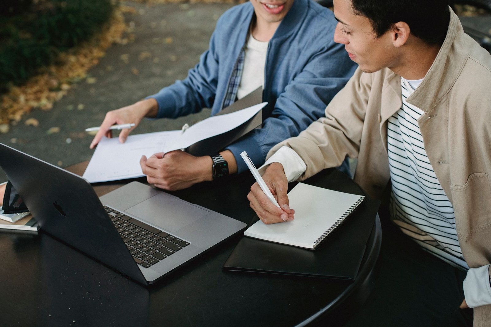 A group of students preparing for a debate with notes and laptops. — debate preparation
