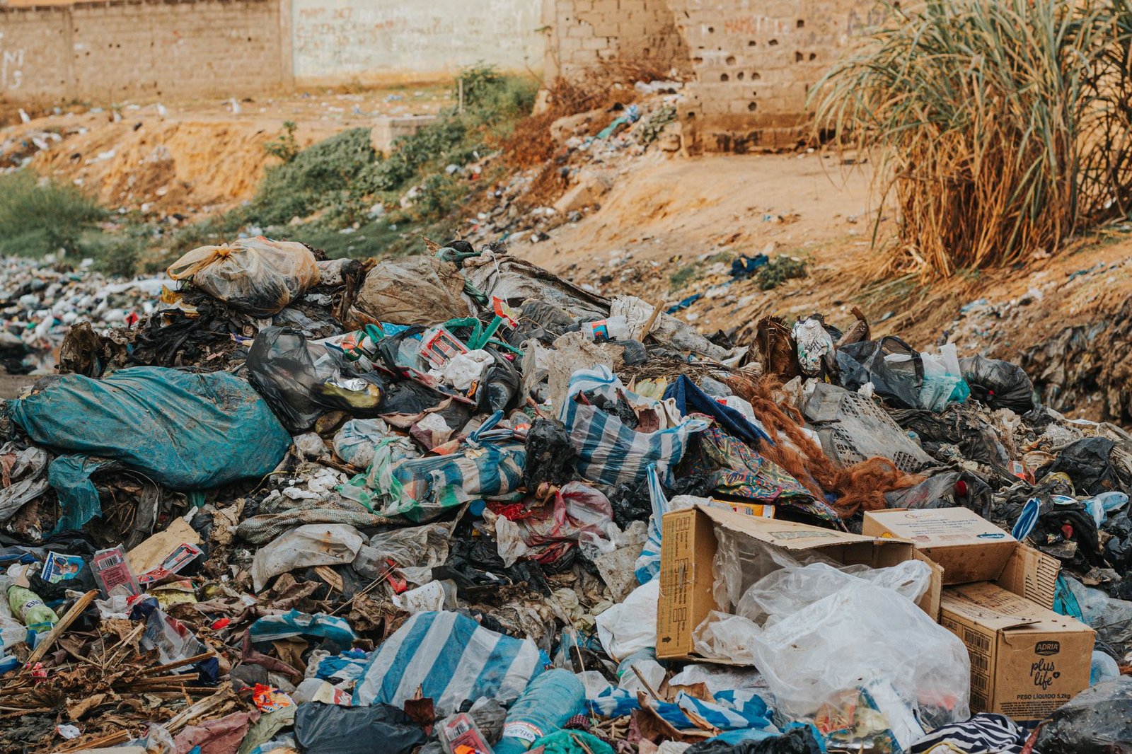 A photo of a landfill filled with discarded clothing items, illustrating waste issues related to the fast fashion debate.