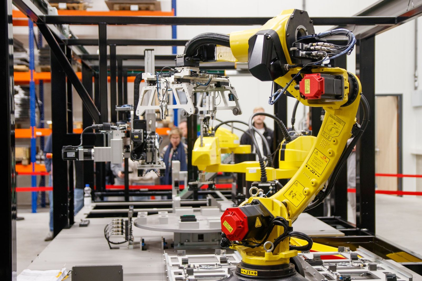 A photo of robots working alongside human employees in a manufacturing plant, illustrating the ongoing automation debate.