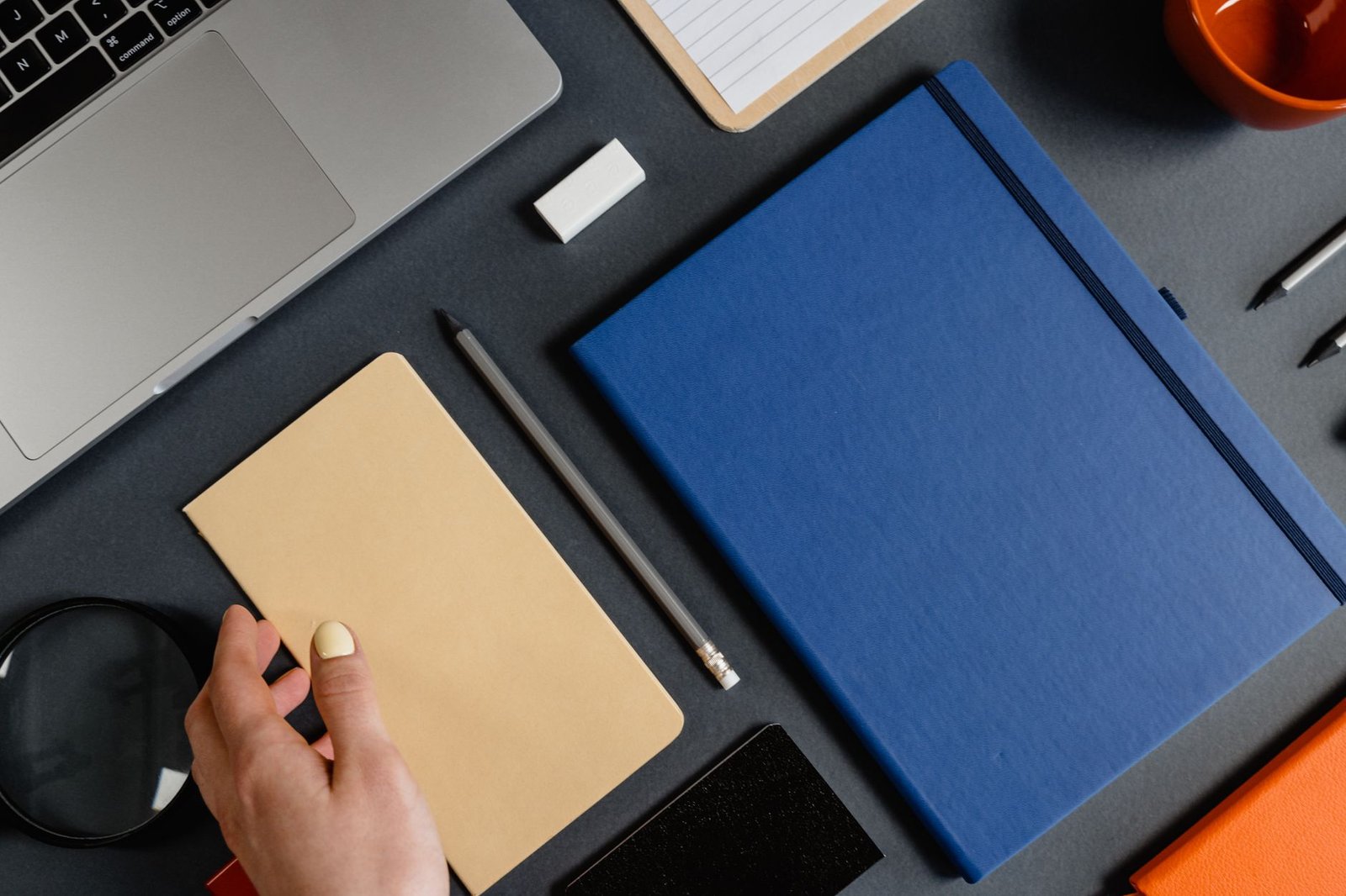 Essential debate materials including notepads, pens, and a laptop, arranged neatly on a table. — debate club essentials