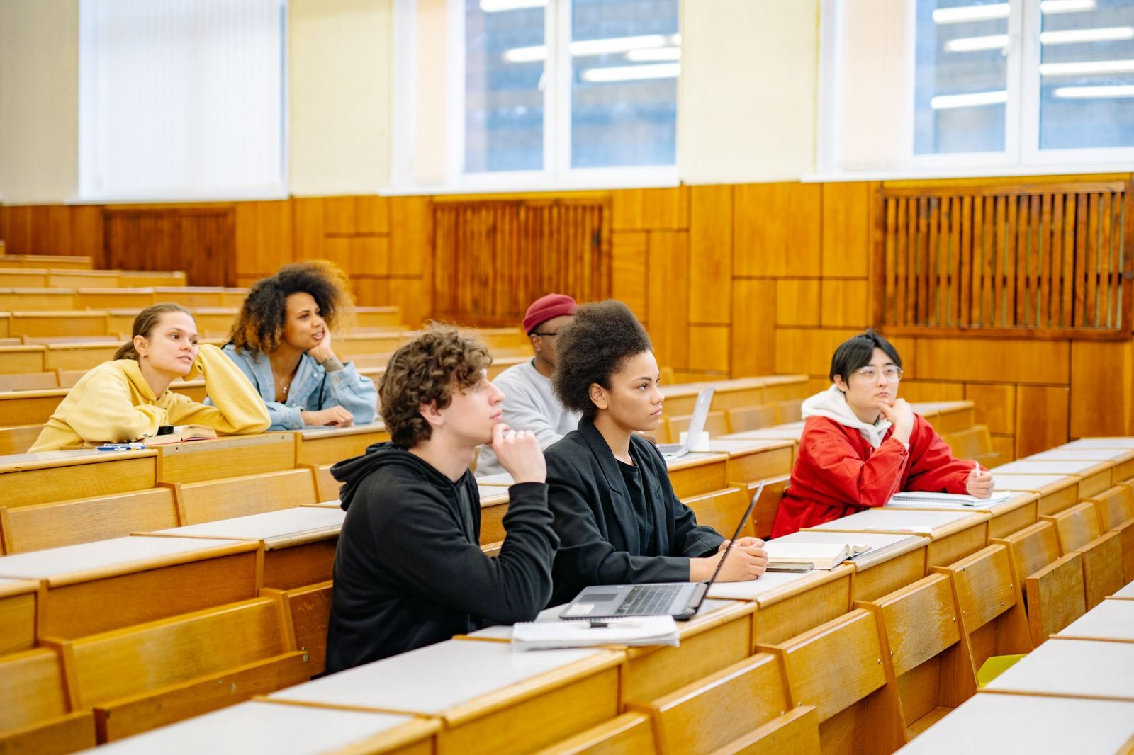 Students of diverse backgrounds attending a college lecture. — college education debates