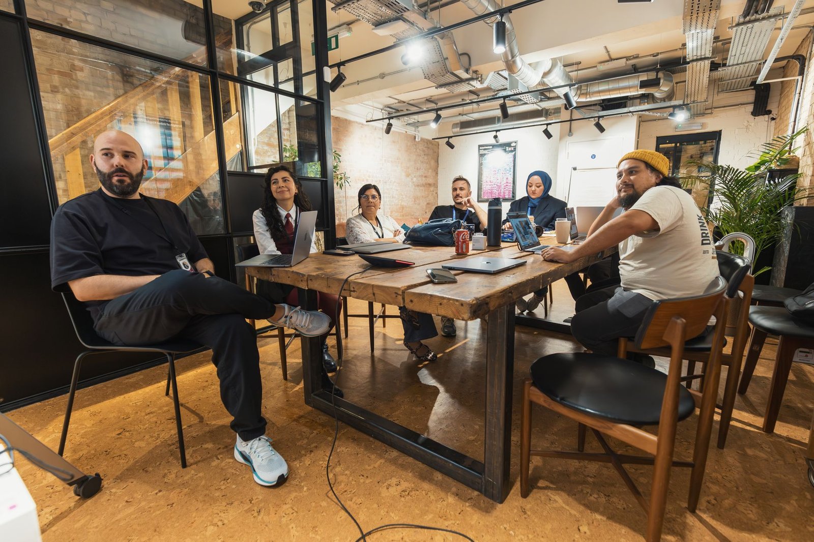 A group of people engaged in a discussion around a table in a collaborative environment. — debate vs discussion
