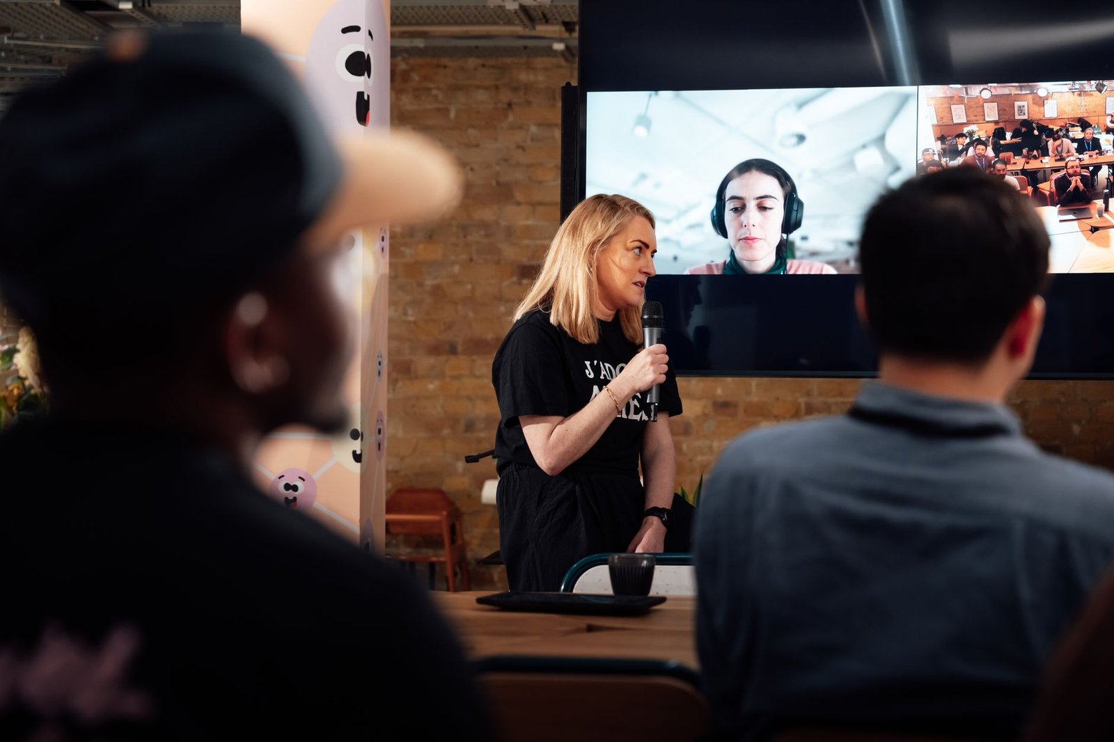 A team meeting in a hybrid setting, with some participants in the office and others on video call. — remote work