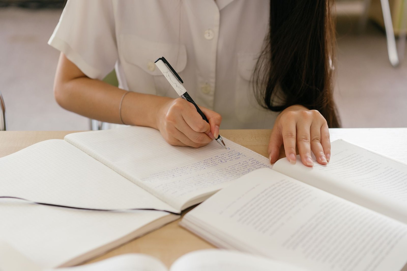 A close-up of a person thoughtfully preparing for a debate, surrounded by notes and books. — clever debates