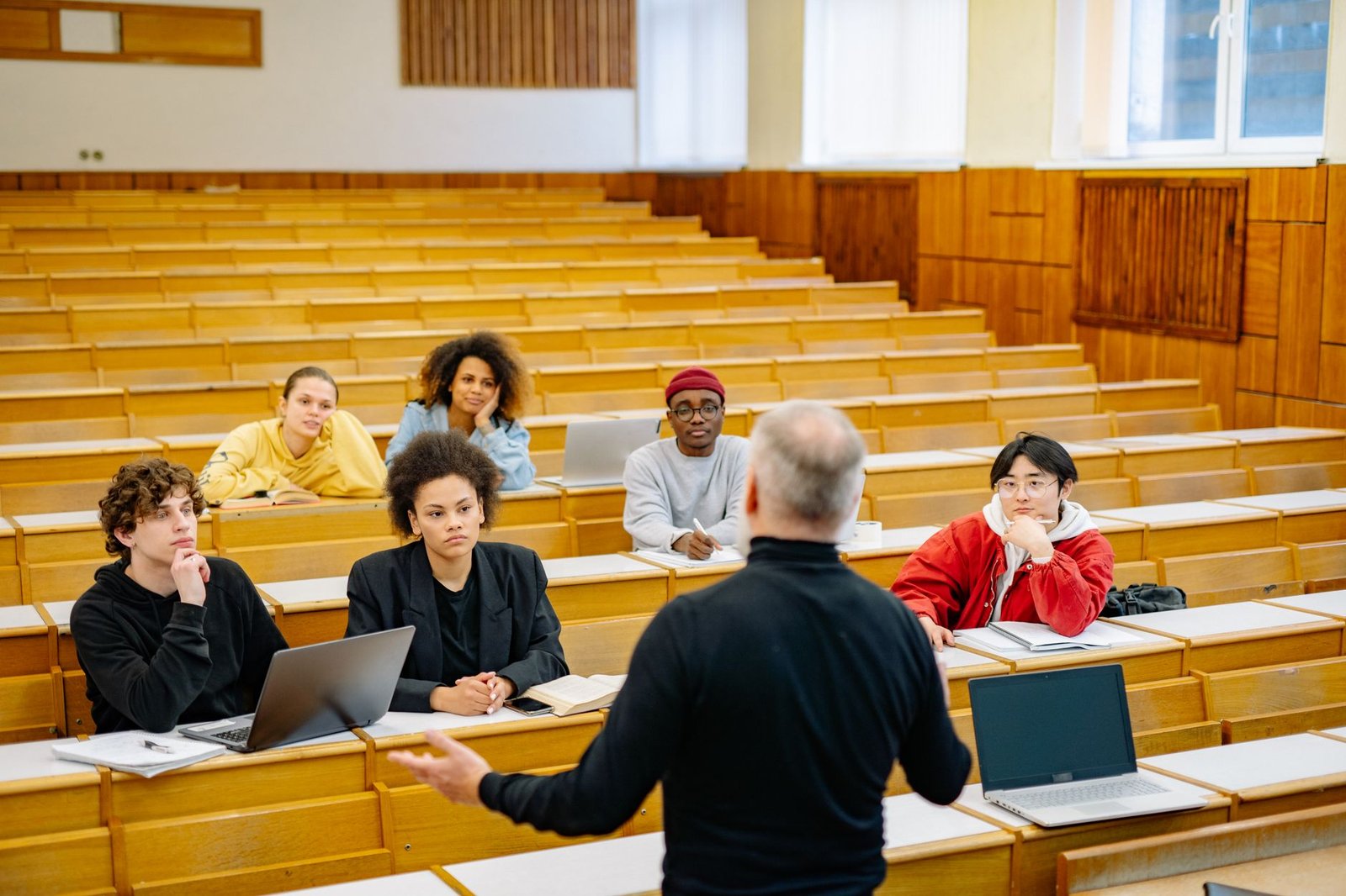 A close-up of a professor lecturing to students, highlighting the exchange of ideas and perspectives in an academic settin…