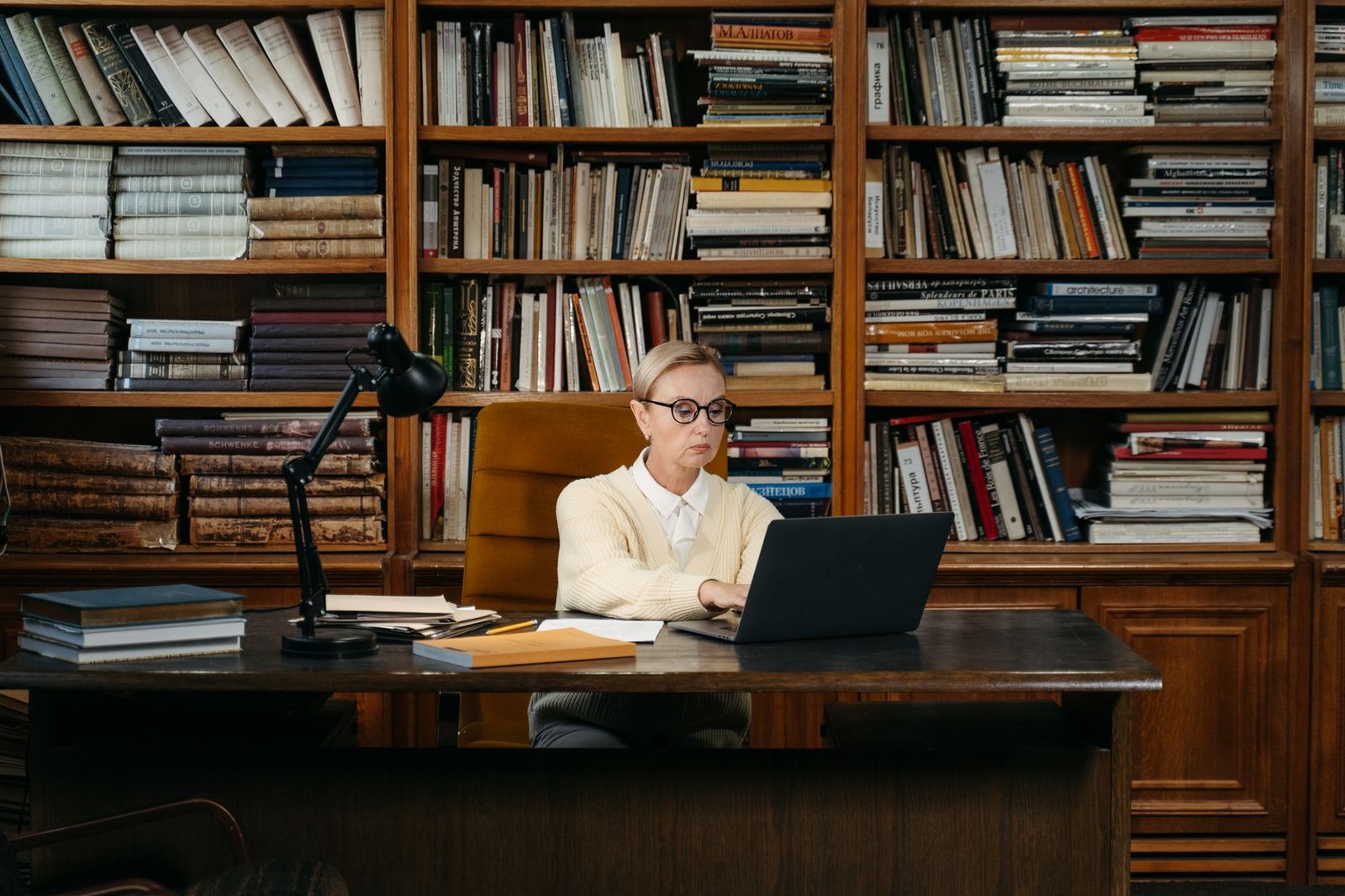 A person researching debate topics with a laptop and books, focusing on gathering information. — debate preparation tips