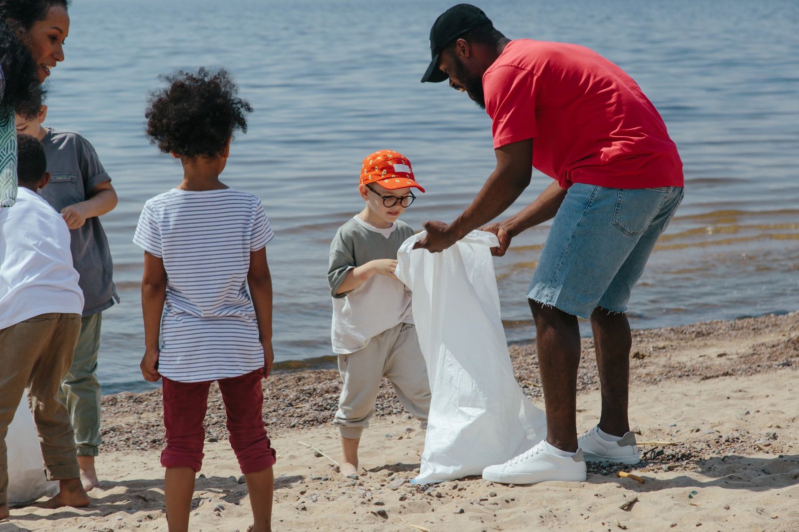 A photo of a clean beach with a sign promoting a plastic ban, showcasing a community's effort towards waste reduction. —…